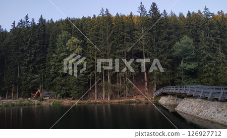 Wooden bridge crossing a lake with snezka mountain and pine forest in background, pec pod snezkou, czechia in august 126927712