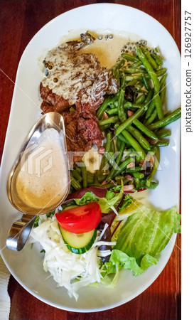 Sliced beef steak with green beans, salad and sauce in konigstein fortress restaurant Sliced beef steak with green beans, salad and sauce in konigstein fortress restaurant 126927757