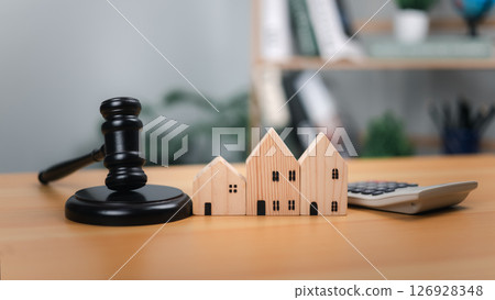 Gavel, houses, calculator. Symbolizes housing law, property valuation, and real estate transactions. Ideal for auctions, legal proceedings, financial decisions in the housing market and related laws. 126928348