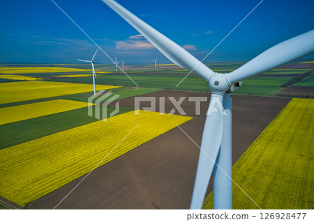 Aerial drone view of wind mills rotating by the force of the wind and generating renewable energy. Renewable alternative energy sources. Aerial drone view of wind mills rotating by the force of the wind and generating renewable energy. Renewable alternative energy sources. 126928477