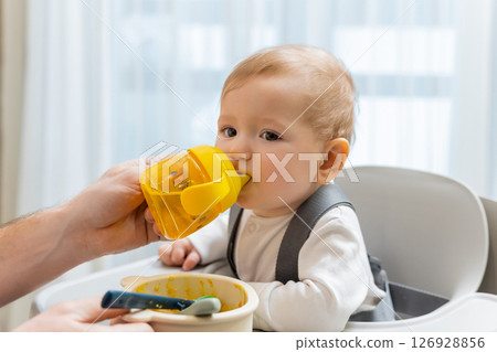 Father and a cute little baby boy having breakfast in the kitchen 126928856