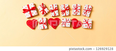 Holiday composition of gift boxes and red textile hearts on colorful background with empty space for your design. Top view of Valentine's Day concept 126929128