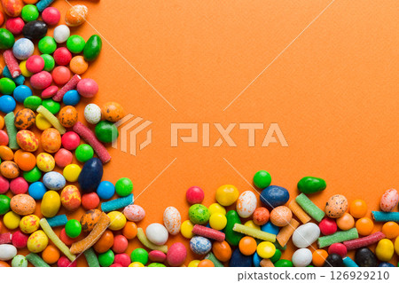 Mixed collection of colorful candy, on colored background. Flat lay, top view. frame of colorful chocolate coated candy 126929210