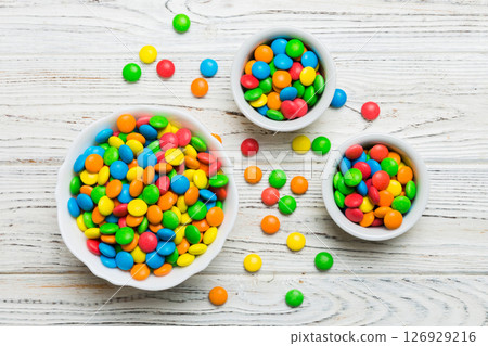 different colored round candy in bowl and jars. Top view of large variety sweets and candies with copy space 126929216