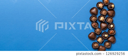 Different kinds of chocolates on colored table close-up. Top View and Flat Lay with copy space Different kinds of chocolates on colored table close-up. Top View and Flat Lay with copy space 126929256