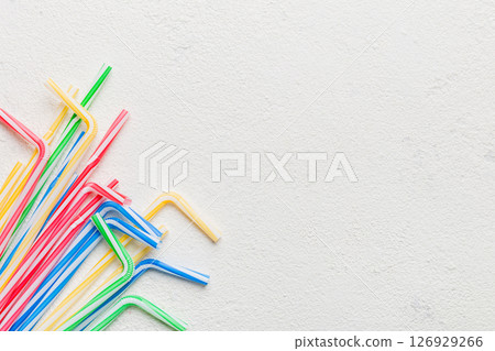Drinking straws for party on Colored background. Top view of colorful plastic disposable straws for summer cocktails. different straws for juice with copy space Drinking straws for party on Colored background. Top view of colorful plastic disposable straws for summer cocktails. different straws for juice with copy space 126929266