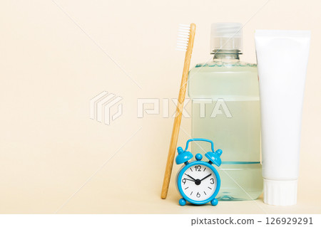 Mouthwash and other oral hygiene products on colored table top view with copy space. Flat lay. Dental hygiene. Oral care products and space for text on light background. concept Mouthwash and other oral hygiene products on colored table top view with copy space. Flat lay. Dental hygiene. Oral care products and space for text on light background. concept 126929291