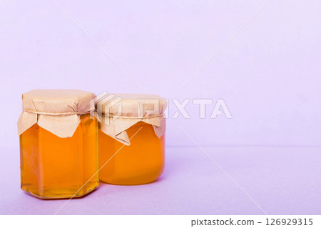 Glass jar full of honey on a colored background. Honey Bottle Mock-Up Glass jar full of honey on a colored background. Honey Bottle Mock-Up 126929315