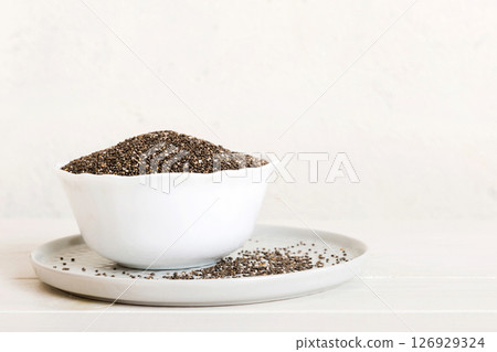 Chia seeds in bowl on colored background. Healthy Salvia hispanica in small bowl. Healthy superfood Chia seeds in bowl on colored background. Healthy Salvia hispanica in small bowl. Healthy superfood 126929324