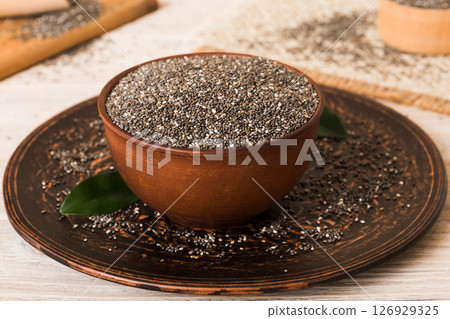 Chia seeds in bowl and spoon on colored background. Healthy Salvia hispanica in small bowl. Healthy superfood Chia seeds in bowl and spoon on colored background. Healthy Salvia hispanica in small bowl. Healthy superfood 126929325
