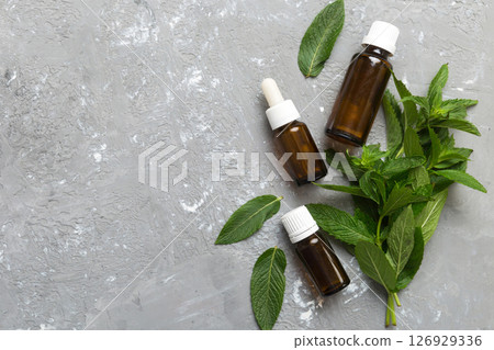 Natural Mint Essential Oil in a Glass Bottle. organic cosmetics with herbal extracts of mint on colored background 126929336