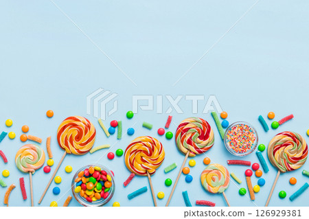Tasty appetizing Party Accessories Happy Birthday Sweet. Different types of candies on colored background, copy space. Colorful birthday party background 126929381