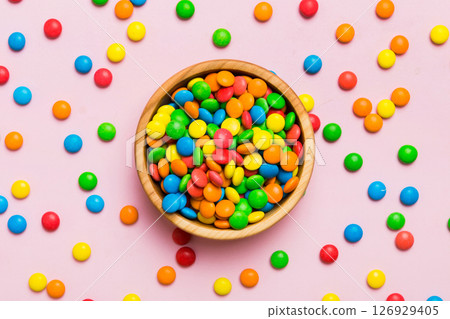 Multicolored candies in a bowl on a colored background. birthday and holiday concept. Top view with copy space Multicolored candies in a bowl on a colored background. birthday and holiday concept. Top view with copy space 126929405