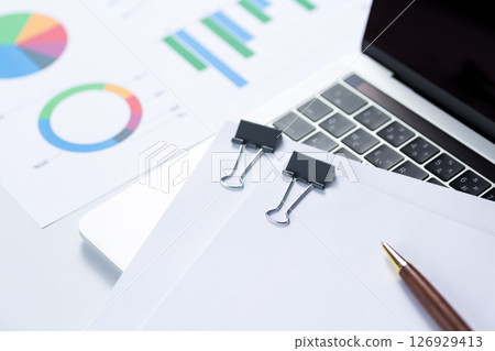 Documents, graphs and a computer clipped together Documents, graphs and a computer clipped together 126929413
