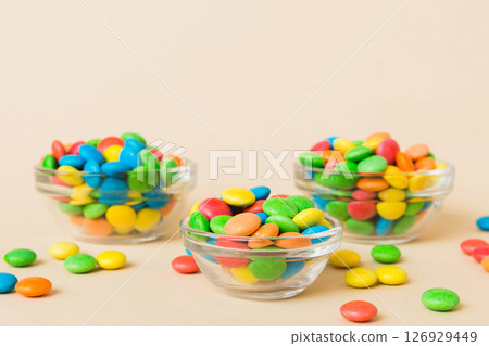 Multicolored candies in a bowl on a colored background. birthday and holiday concept. Top view with copy space Multicolored candies in a bowl on a colored background. birthday and holiday concept. Top view with copy space 126929449