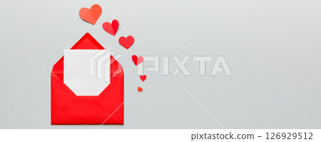 Red paper envelope with empty white card and heart on colored background. top view valentines day concept 126929512