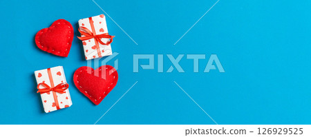 Top view of gift boxes and red textile hearts on colorful background. St Valentine's day concept with copy space Top view of gift boxes and red textile hearts on colorful background. St Valentine's day concept with copy space 126929525