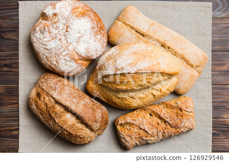 Assortment of freshly baked bread with napkin on rustic table top view. Healthy unleavened bread. French bread 126929546