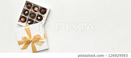 White box with chocolates candies and golden tape. top view with copy space 126929563
