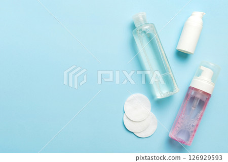 Micellar cleansing water and discs to remove cosmetics and cleanse the skin on colored background. Copy space top view Micellar cleansing water and discs to remove cosmetics and cleanse the skin on colored background. Copy space top view 126929593