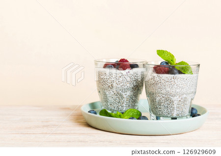 Healthy breakfast or morning with chia seeds vanilla pudding raspberry and blueberry berries on table background, vegetarian food, diet and health concept. Chia pudding with raspberry and blueberry Healthy breakfast or morning with chia seeds vanilla pudding raspberry and blueberry berries on table background, vegetarian food, diet and health concept. Chia pudding with raspberry and blueberry 126929609