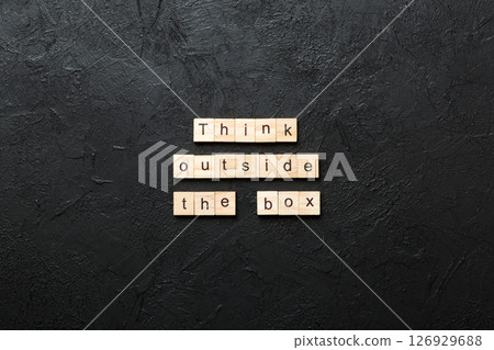 Think outside the box word written on wood block. Think outside the box text on cement table for your desing, Top view concept 126929688