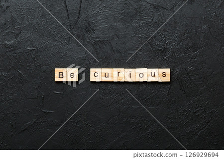 be curious word written on wood block. be curious text on table, concept be curious word written on wood block. be curious text on table, concept 126929694