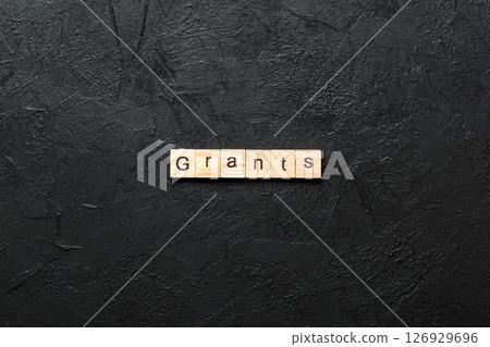 grants word written on wood block. grants text on table, concept 126929696