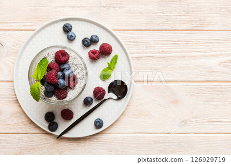 Healthy breakfast or morning with chia seeds vanilla pudding raspberry and blueberry berries on table background, vegetarian food, diet and health concept. Chia pudding with raspberry and blueberry Healthy breakfast or morning with chia seeds vanilla pudding raspberry and blueberry berries on table background, vegetarian food, diet and health concept. Chia pudding with raspberry and blueberry 126929719