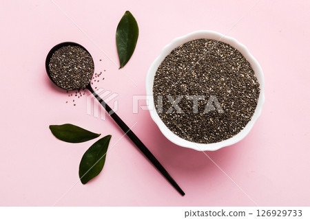 Chia seeds in bowl and spoon on colored background. Healthy Salvia hispanica in small bowl. Healthy superfood Chia seeds in bowl and spoon on colored background. Healthy Salvia hispanica in small bowl. Healthy superfood 126929733