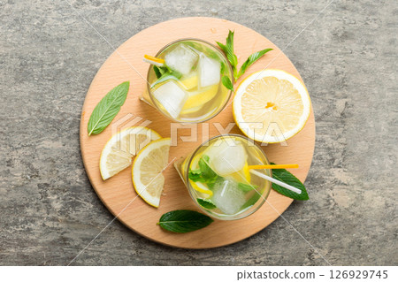Caipirinha, Mojito cocktail, vodka or soda drink with lime, mint and straw on table background. Refreshing beverage with mint and lime in glass top view flat lay 126929745