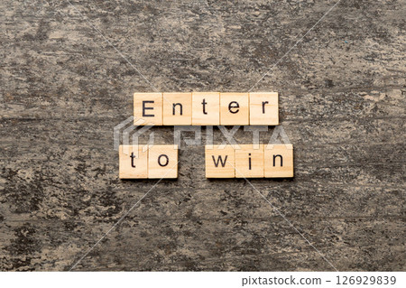 Enter To Win word written on wood block. Enter To Win text on cement table for your desing, concept Enter To Win word written on wood block. Enter To Win text on cement table for your desing, concept 126929839