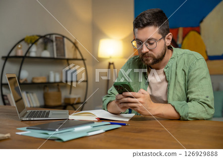 Bearded man reviewing feedback in home office 126929888