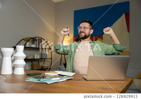 Happy businessman warming up body and muscles at workplace feeling satisfied with work done Happy businessman warming up body and muscles at workplace feeling satisfied with work done 126929911