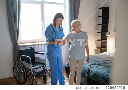 Female doctor in rehabilitation center examining elderly patient 126929926