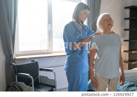 Female doctor in rehabilitation center examining elderly patient 126929927