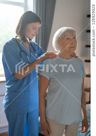 Female doctor in rehabilitation center examining elderly patient Female doctor in rehabilitation center examining elderly patient 126929928