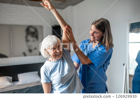 Female doctor in rehabilitation center examining elderly patient 126929930
