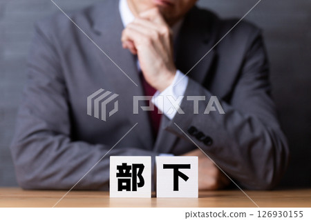 A middle-aged male businessman wearing a suit and worried about his subordinate's block 126930155