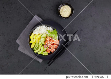Poke bowl with salmon, rice, avocado, cucumber, mango, greens. Poke bowl with salmon, rice, avocado, cucumber, mango, greens. 126930291