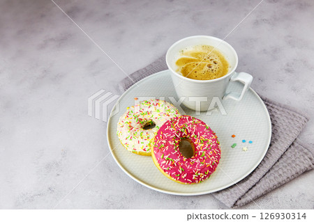 Colorful donuts and cup of coffee on grey background. Colorful donuts and cup of coffee on grey background. 126930314
