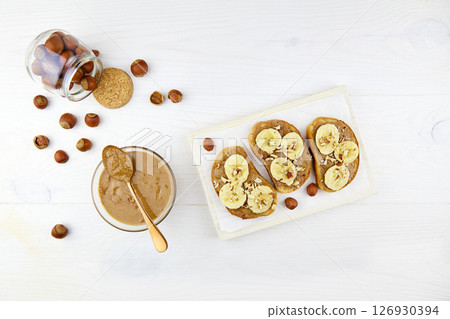 Homemade raw organic hazelnut paste. Toasts with hazelnut butter and banana 126930394