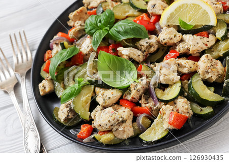 baked italian chicken and vegetables on a plate 126930435