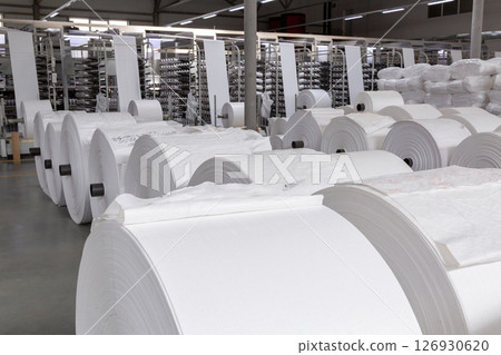 A warehouse with large white rolls of polypropylene. A warehouse with large white rolls of polypropylene. 126930620