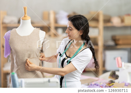 Armenian seamstress working near mannequin in workshop Armenian seamstress working near mannequin in workshop 126930711