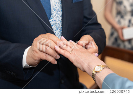 The groom puts a ring on the bride's finger The groom puts a ring on the bride's finger 126930745