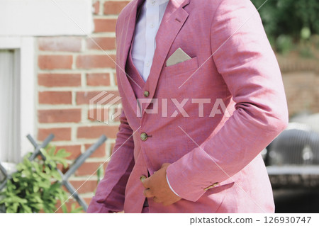Groom in a pink suit jacket at a wedding Groom in a pink suit jacket at a wedding 126930747