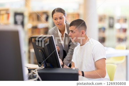 guy is working at a computer against the background of a young woman guy is working at a computer against the background of a young woman 126930808