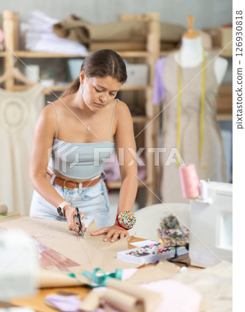 Female fashion designer cutting paper 126930818