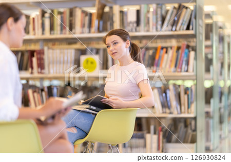 Students sit in chairs and study literature in reading room 126930824